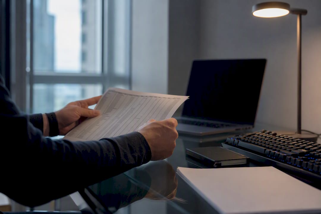 Hands checking CSV spreadsheet on desk